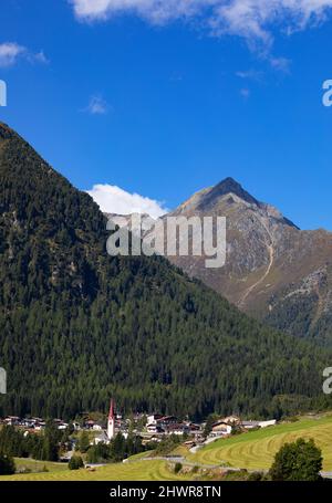 Austria, Tyrol, Sankt Sigmund im Sellrain, Aerial view of village at foot of forested mountain in Sellrain Valley Stock Photo