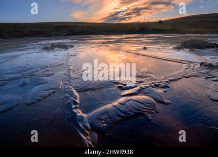Surface of frozen lake at winter dawn Stock Photo