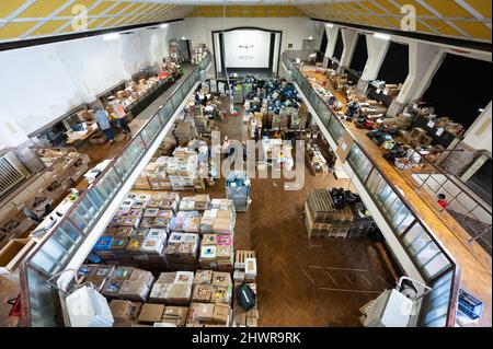 07 March 2022, Saxony, Dresden: Volunteers sort donations in kind into boxes at a donation warehouse for people in Ukraine. Donations in kind for aid convoys to Ukraine are collected in the event hall. Photo: Sebastian Kahnert/dpa-Zentralbild/dpa Stock Photo