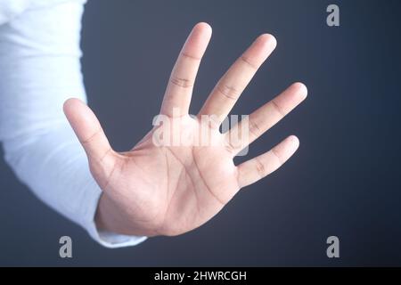 young man show stop sigh isolated in black  Stock Photo