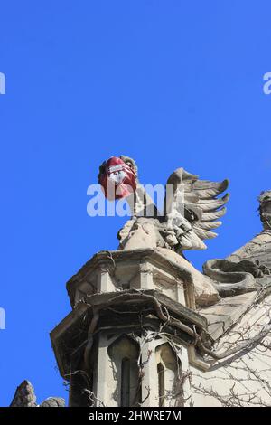 Old Gothic medieval gargoyle wearing a covid 19 pandemic face mask. Stock Photo