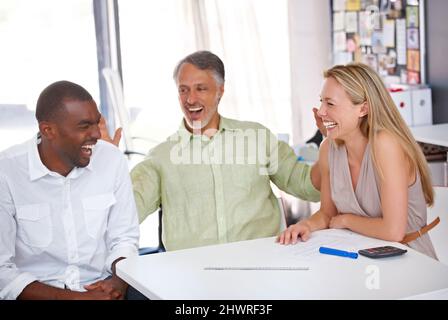 Working together on a great design. Three designers having a meeting. Stock Photo
