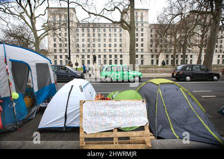 A sign speaks of peace and unity at roadside tents opposite government offices that provide homes for protesters. The Freedom Convoy Camp set up permanently on the Embankment after the Freedom Convoy came to London in February 2022. They support the people who are fighting authoritarian governments living under onerous coronavirus laws in Canada, Austria and Australia. They are also fighting against vaccination for children in the UK. Until governments return all freedoms taken from the people in the last two years they intend to stay put.