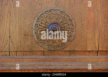 Weathered wooden door with decorative round handle. Stock Photo