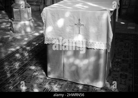 Light spots on altar and floor in church. Sunlight filtered through the stained glass window. A game of light and shadow. Black white historic photo Stock Photo
