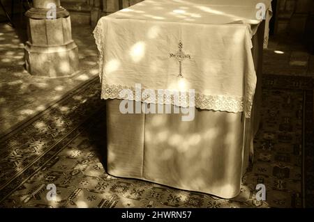 Light spots on altar and floor in church. Sunlight filtered through the stained glass window. A game of light and shadow. Sepia historic photo Stock Photo