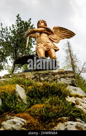 Saint Michael defeats Satan. Park sculpture in Annecy lake area. Duingt, France. Good triumphs over evil concept. Stock Photo