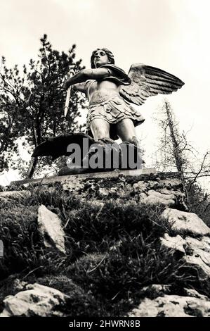 Saint Michael defeats Satan. Park sculpture in Annecy lake area (Duingt, France). Good triumphs over evil concept. Black and white. Stock Photo