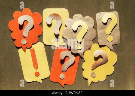 Question mark on speech bubbles, golden background. View from above. Problem and solution concept. Brainstorm. Stock Photo