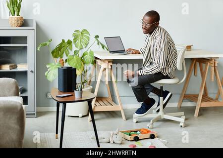 Full length portrait of African American man using voice activated smart speaker in minimal home interior, copy space Stock Photo