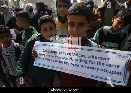 Rafah, Gaza. 07th Mar, 2022. Young Palestinian boys lift placards during a rally demanding international support for Palestinians against Israel at the Rafah refugee camp in the Gaza Strip on Monday, March 7, 2022. The placards are similar to those shown for Ukrainians against Russia. Photo by Ismael Mohamad/UPI Credit: UPI/Alamy Live News Stock Photo