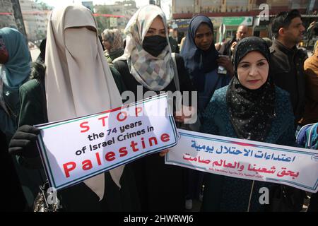Rafah, Gaza. 07th Mar, 2022. Palestinian women lift placards during a rally demanding international support for Palestinians against Israel at the Rafah refugee camp in the Gaza Strip on Monday, March 7, 2022. The placards are similar to those shown for Ukrainians against Russia. Photo by Ismael Mohamad/UPI Credit: UPI/Alamy Live News Stock Photo