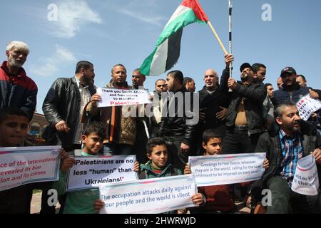 Rafah, Gaza. 07th Mar, 2022. Palestinians lift placards during a rally demanding international support for Palestinians against Israel at the Rafah refugee camp in the Gaza Strip on Monday, March 7, 2022. The placards are similar to those shown for Ukrainians against Russia. Photo by Ismael Mohamad/UPI Credit: UPI/Alamy Live News Stock Photo