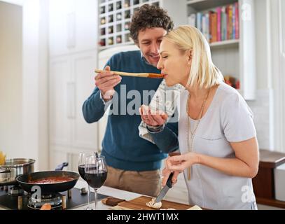 The kitchen is the heart of this home. Shot of a happy couple cooking dinner together in their kitchen. Stock Photo