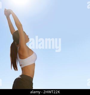 Embracing the world before a workout. A pretty spo stretching her arms out before a workout. Stock Photo