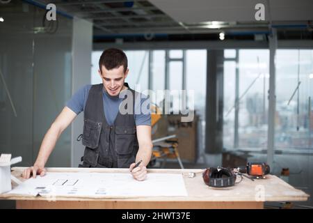 Making some quick changes. Young architect working on his plans while at a construction site. Stock Photo