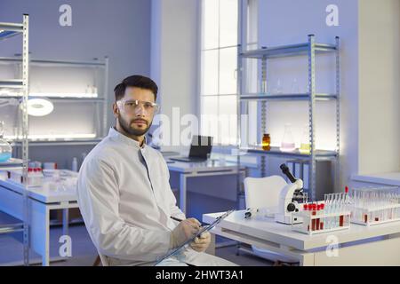 Portrait of smart young Caucasian researcher working in modern medical laboratory. Stock Photo