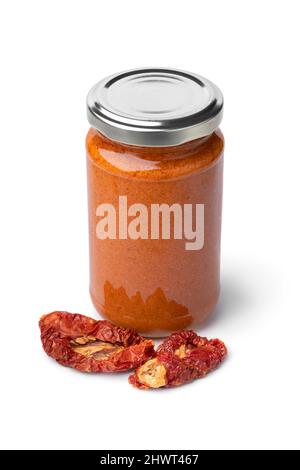 Glass jar with red Italian pesto and dried sweet tomatoes in front  isolated on white background Stock Photo