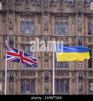 London, UK 6th March 2022. A Ukrainian flag flies alongside the Union Jack outside the UK Parliament in support of Ukraine. Stock Photo