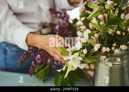 Mature woman making bouquet of garden flowers Stock Photo