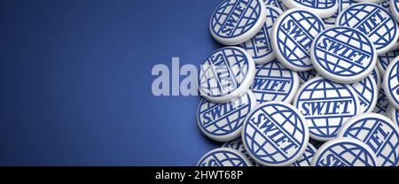 3d Logos of the executor of financial transaction between banks S.W.I.F.T. (Society for Worldwide Interbank Financial Telecommunication) on a heap on Stock Photo