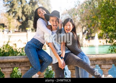 Three friends having fun visiting a landmark and looking at the camera Stock Photo
