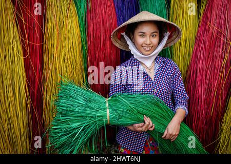 Vietnamese women drying traditional vietnam mats in the old traditional village at dinh yen, dong thap, vietnam, tradition artist concept,Vietnam. Stock Photo