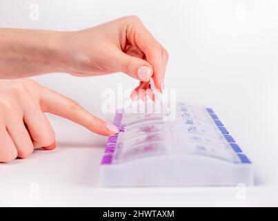 Woman hands opening weekly pills box. Reminder and organizer for daily taking tablets and vitamins. High quality photo Stock Photo