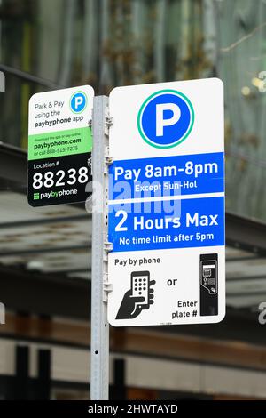 Seattle, WA, USA - March 06, 2022; Sign in downtown Seattle for street pay parking with instructions of how to pay by phone or with machines and hours Stock Photo