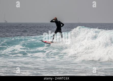 Surfers catching the waves near Playa de las Americas, Tenerife Stock Photo