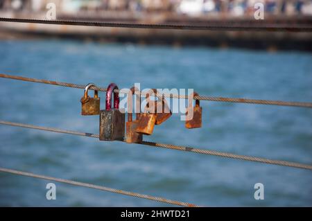 Rusty Love locks attached to railing in Tel Aviv port, Israel. Old love concept. Stock Photo