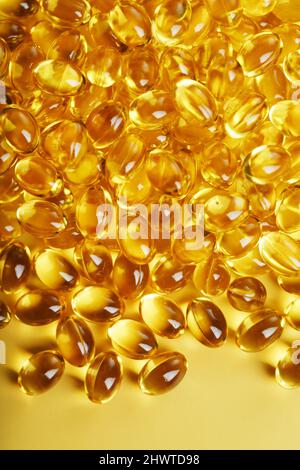 The texture of the capsules in the shell with liquid vitamin D3 in full screen. Gold capsules with a dietary supplement for joints teeth and bones. Stock Photo