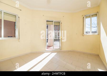 empty room with two windows and exit to a balcony in the center where a lot of sun enters in the morning Stock Photo