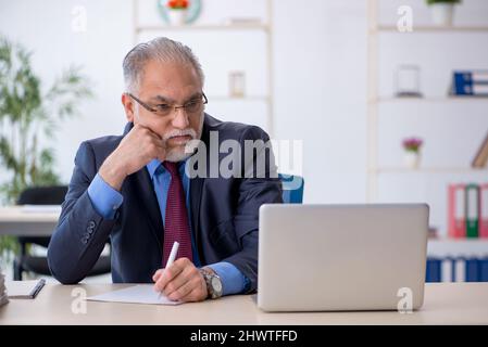 Old businessman employee working at workplace Stock Photo