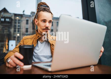 Young male hipster working on notebook in street Stock Photo