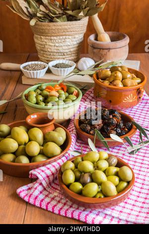 Still life with different varieties of olives, presented in bowls, dressed with different traditional dressings. Traditional homemade dressings, typic Stock Photo