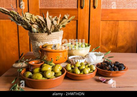 Still life with different varieties of olives, presented in bowls, dressed with different traditional dressings. Traditional homemade dressings, typic Stock Photo