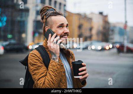 Smiling young man making call in city centre Stock Photo