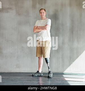 Totally abled. Shot of a young man with an artificial leg standing confidently in a gym. Stock Photo
