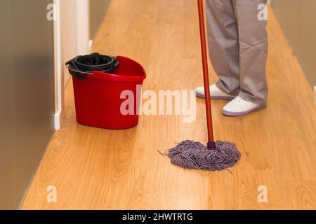 Close up view of a cleaning staff using a mop to clean the floor. Stock Photo