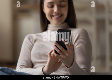 Happy young woman use smartphone, closeup focus on device Stock Photo
