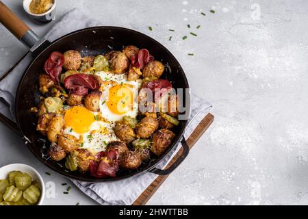 Home fried potatoes iln a cast iron skillet with serving plates Stock Photo  - Alamy