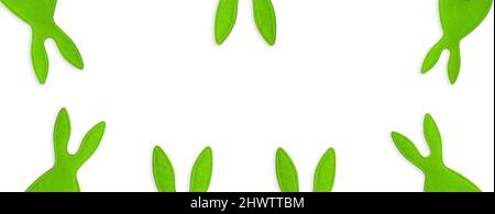Stitched green rabbits peeking out on white isolated background. Banner, holiday, symbol of Easter, New year. Copy space Stock Photo