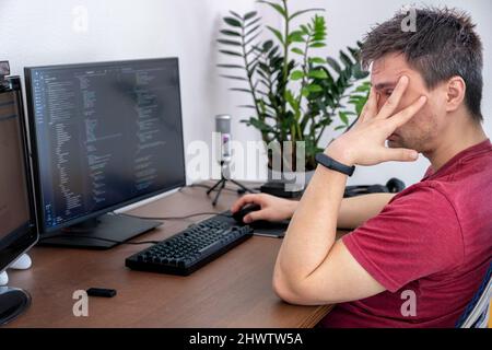 Computer programmer writing program code on computer at home Stock Photo