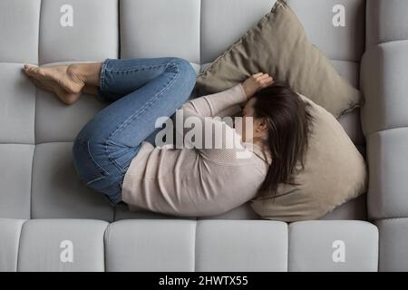 Top view depressed young woman lying on sofa Stock Photo