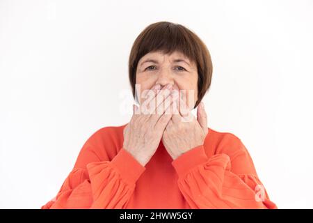 Old brunette woman making the speak no gesture from the three wise monkeys - studio photo Stock Photo