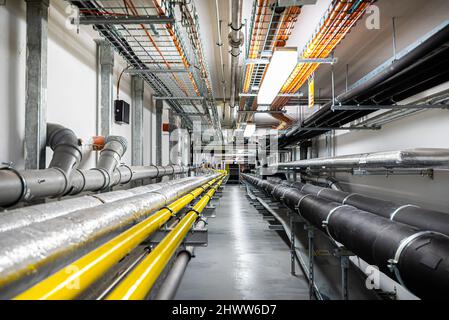 Gas and waste pipelines in the underground premises of the factory, industrial background Stock Photo
