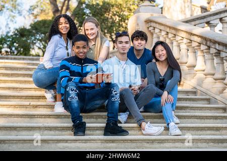 Group of young students looking to the camera on some stairs Stock Photo