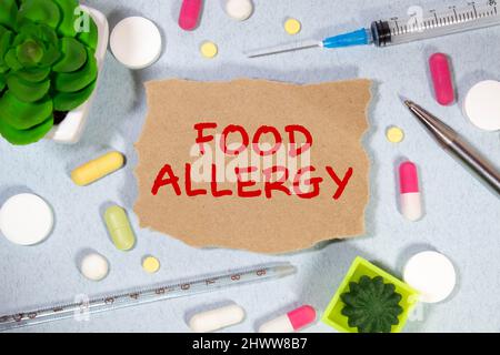 FOOD ALLERGY handwritten with white chalk on a blackboard on wood background. Stock Photo