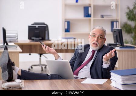 Old businessman employee working in the office Stock Photo